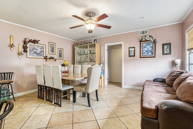 dining area with a textured ceiling, ceiling fan, ornamental molding, and light tile patterned flooring