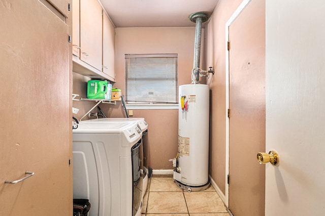 clothes washing area featuring gas water heater, light tile patterned floors, cabinets, and washing machine and clothes dryer