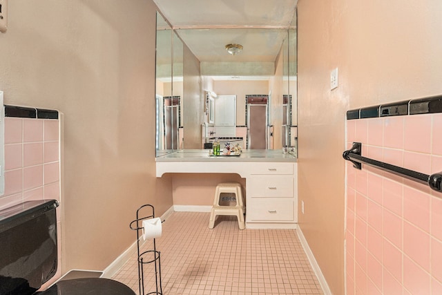 bathroom with tile patterned floors, tile walls, and vanity