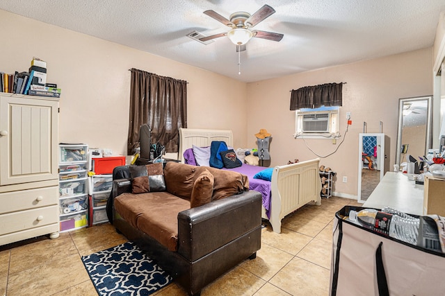 bedroom with cooling unit, ceiling fan, light tile patterned flooring, and a textured ceiling