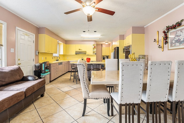 dining area featuring ornamental molding, a textured ceiling, light tile patterned floors, sink, and ceiling fan