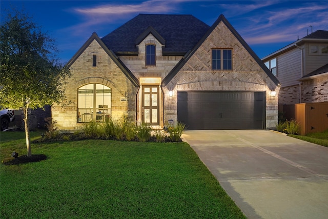 view of front facade featuring a lawn, a garage, and french doors