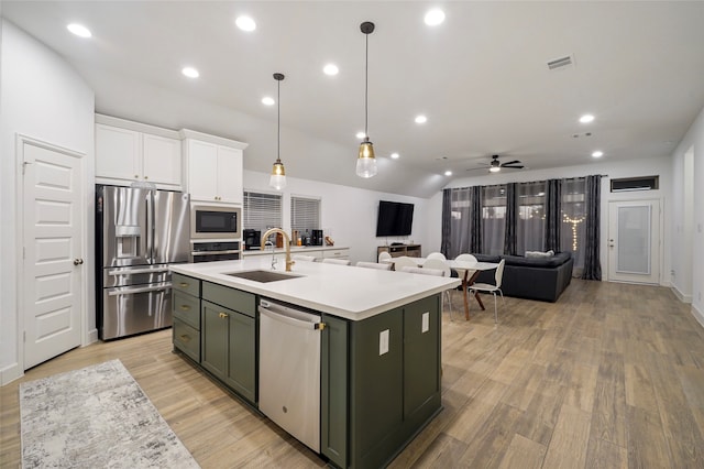 kitchen featuring white cabinets, appliances with stainless steel finishes, sink, ceiling fan, and a center island with sink