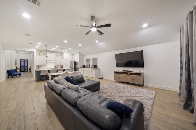 living room with ceiling fan and light hardwood / wood-style floors