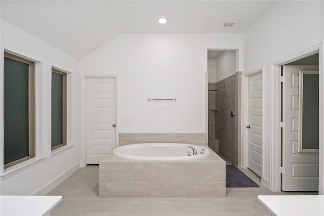 bathroom with vaulted ceiling, tile patterned floors, and shower with separate bathtub