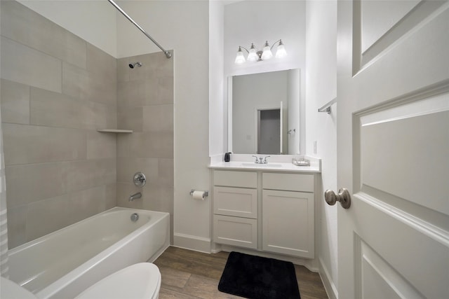 full bathroom with tiled shower / bath, vanity, toilet, and wood-type flooring