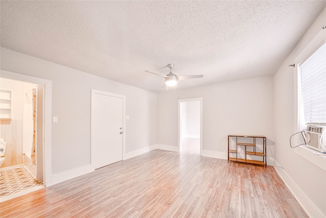 spare room featuring a textured ceiling, light hardwood / wood-style flooring, and ceiling fan