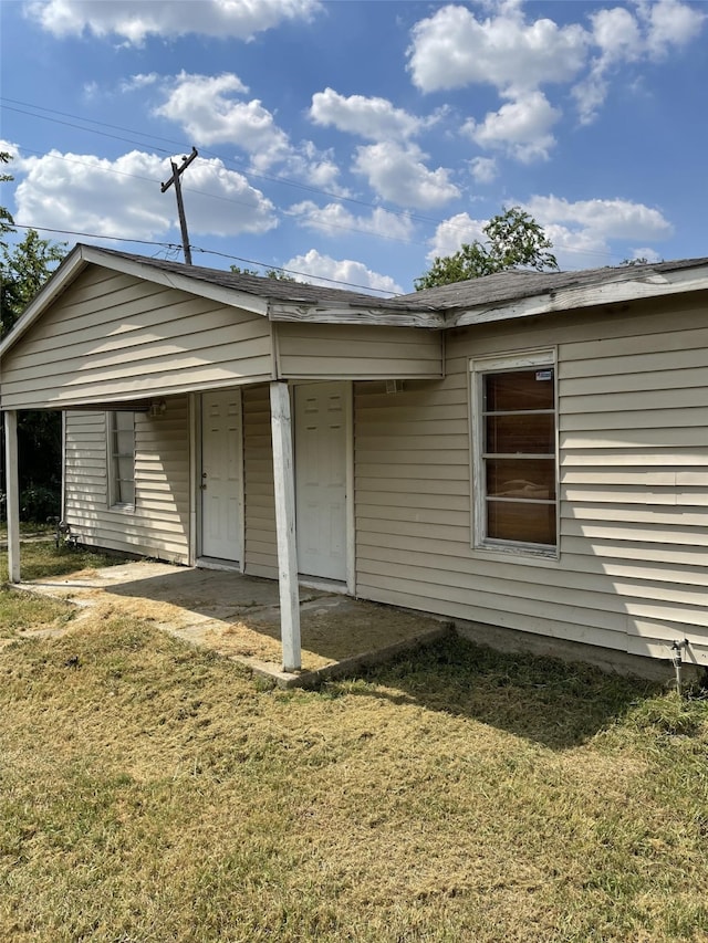 view of side of property with a yard and a patio