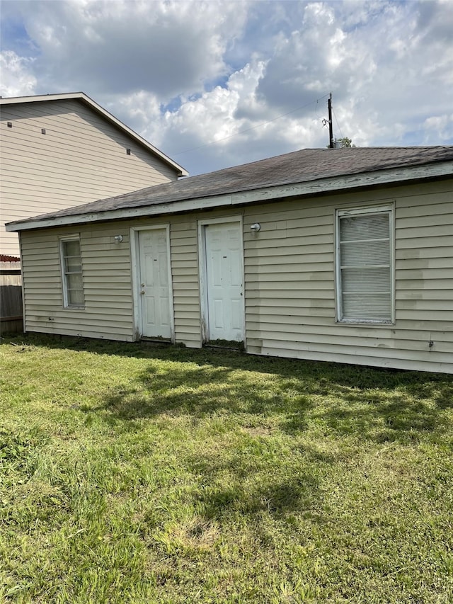 rear view of house featuring a yard