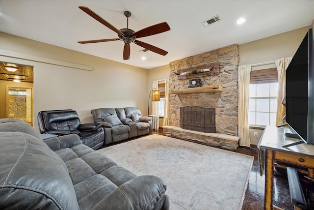 living room featuring ceiling fan and a fireplace