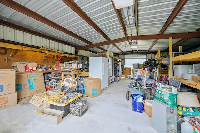 garage featuring a workshop area and white fridge