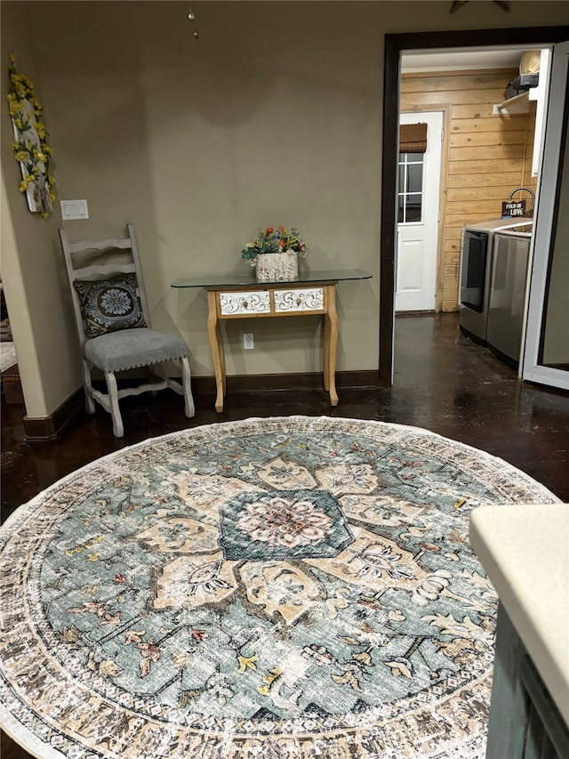 living area with independent washer and dryer and wooden walls