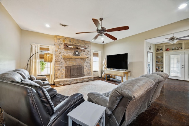 living room with built in shelves, ceiling fan, a healthy amount of sunlight, and a fireplace