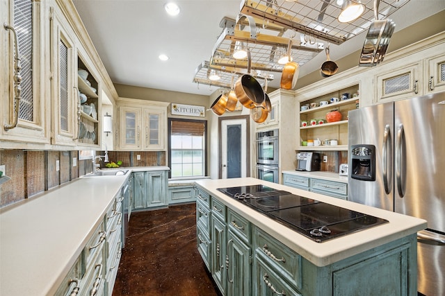 kitchen featuring sink, backsplash, appliances with stainless steel finishes, a kitchen island, and green cabinetry