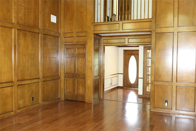 foyer with wood-type flooring and wood walls