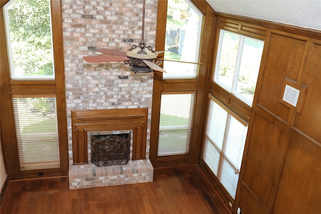 unfurnished living room featuring a brick fireplace and dark hardwood / wood-style flooring