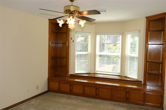 interior space featuring light carpet, ceiling fan, and a textured ceiling