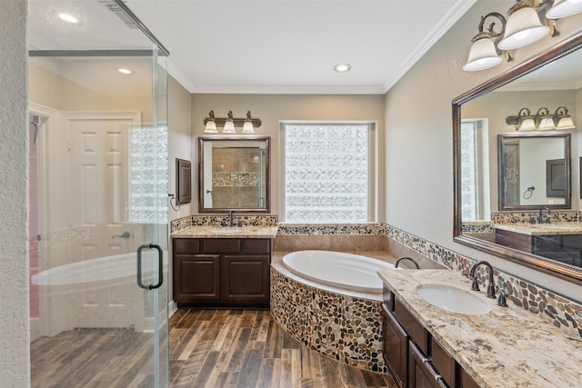 full bathroom with a sink, a garden tub, a stall shower, and crown molding