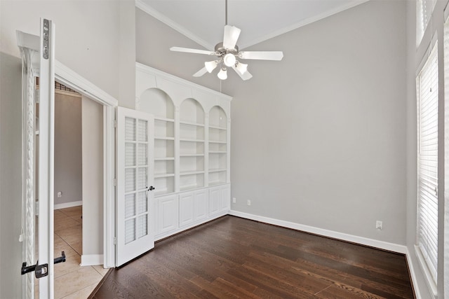 unfurnished bedroom with crown molding, dark wood-style floors, and baseboards