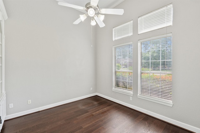 unfurnished room with baseboards, dark wood-type flooring, and ceiling fan