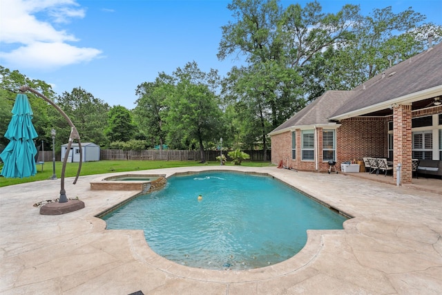 view of swimming pool with a pool with connected hot tub, a shed, a fenced backyard, an outbuilding, and a patio