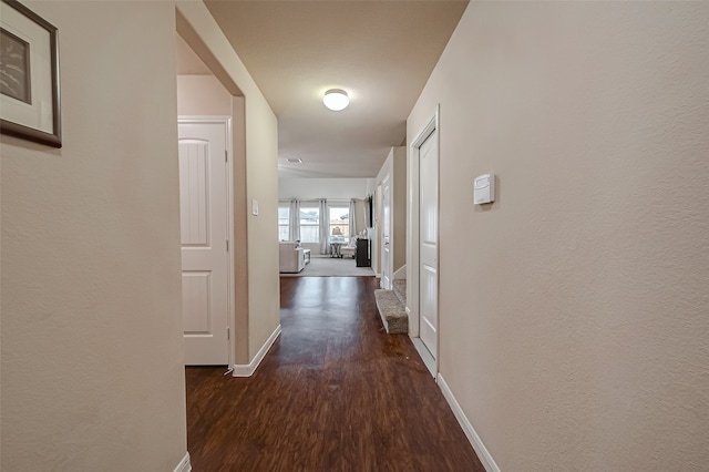 corridor with dark hardwood / wood-style flooring