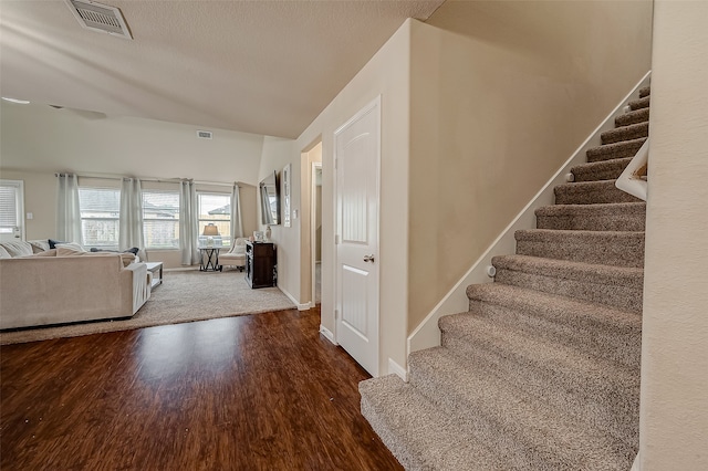 stairway with lofted ceiling and hardwood / wood-style flooring