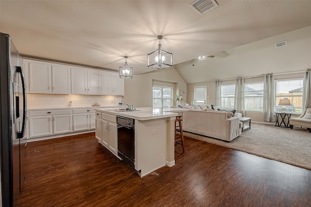 kitchen with white cabinetry, hanging light fixtures, an island with sink, lofted ceiling, and dishwasher