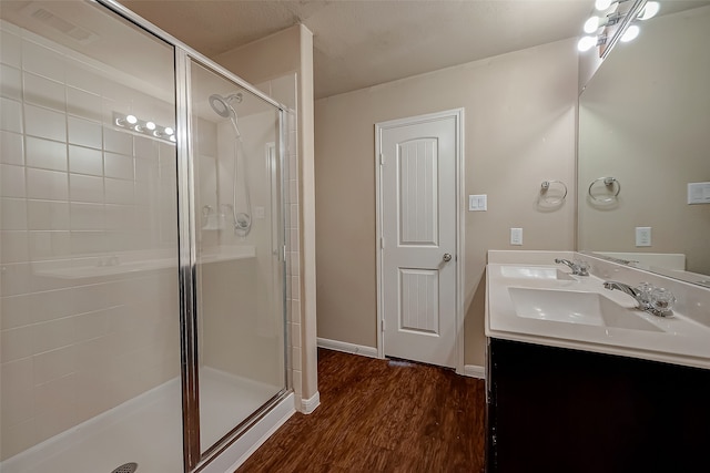 bathroom featuring walk in shower, wood-type flooring, and vanity