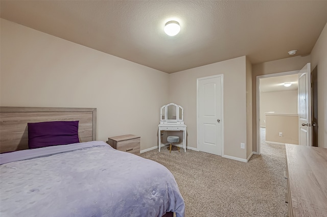 bedroom with light colored carpet and a textured ceiling