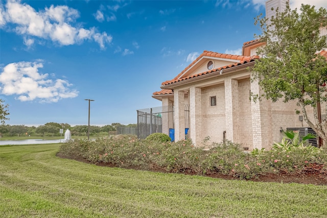 view of property exterior featuring a water view and a lawn