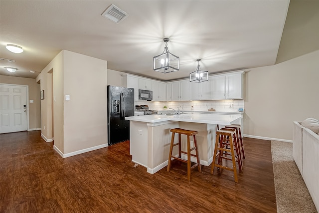 kitchen featuring black appliances, a breakfast bar area, a kitchen island with sink, white cabinets, and decorative backsplash