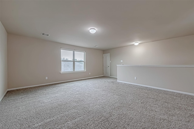 unfurnished room with light carpet, visible vents, and baseboards