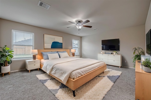 carpeted bedroom with a ceiling fan, visible vents, and baseboards