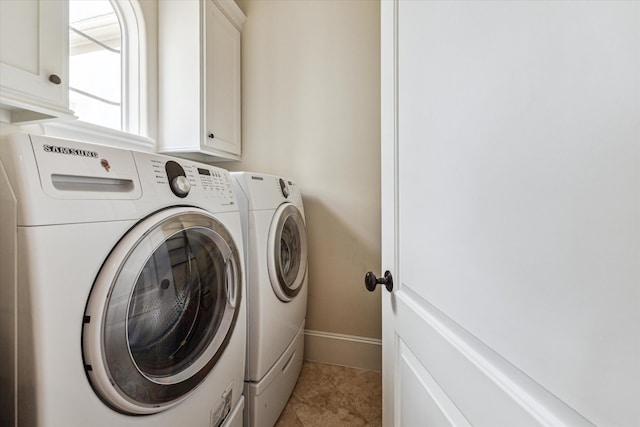 laundry room featuring light tile patterned floors, cabinets, and washer and dryer