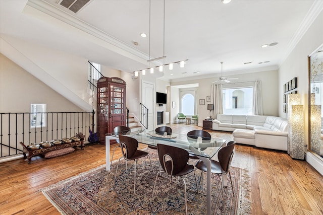 dining area featuring light wood-type flooring, ceiling fan, crown molding, and a healthy amount of sunlight