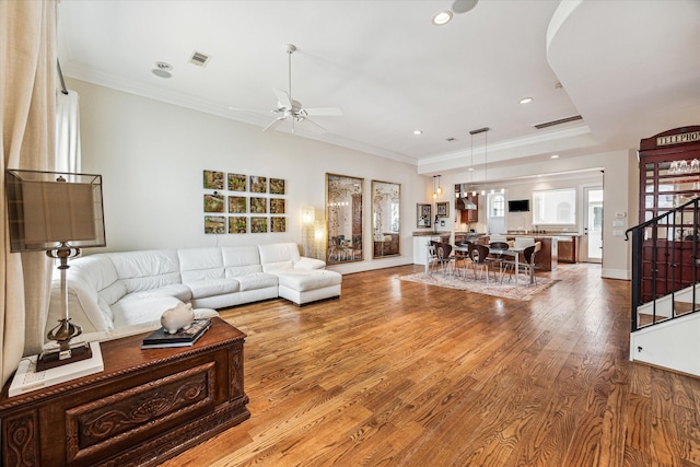 living room featuring ceiling fan, light hardwood / wood-style floors, and ornamental molding