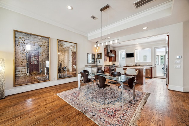 dining area featuring ornamental molding and wood-type flooring