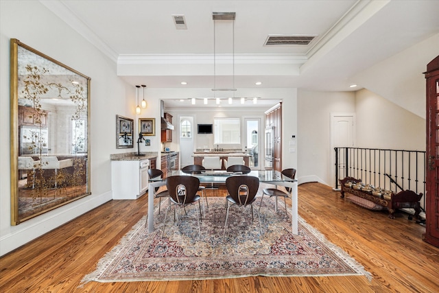 dining room featuring crown molding and light hardwood / wood-style floors