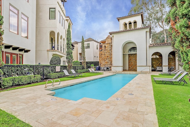 view of swimming pool featuring a yard and a patio