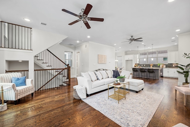 living room featuring ceiling fan, dark hardwood / wood-style floors, and ornamental molding