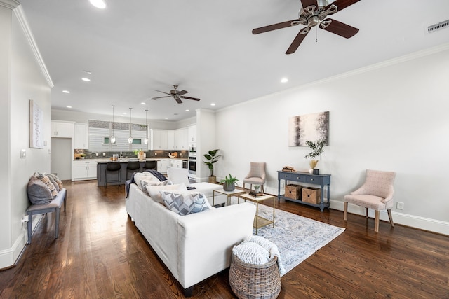 living room with dark wood-type flooring, ornamental molding, and ceiling fan