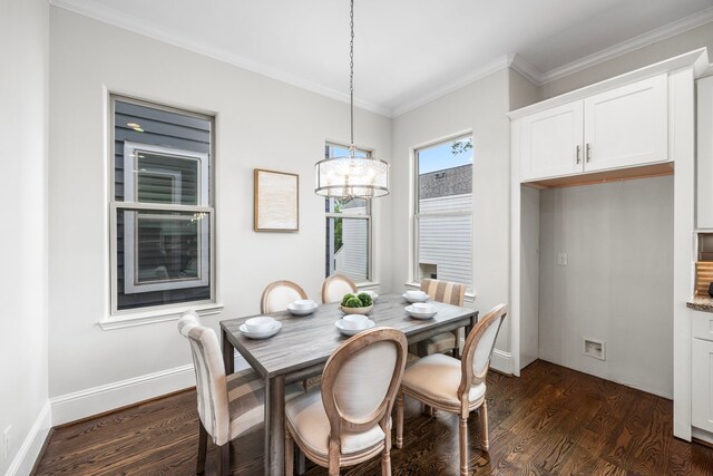 dining space with dark wood-type flooring, crown molding, and a chandelier