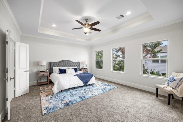 carpeted bedroom with ceiling fan, a tray ceiling, and crown molding