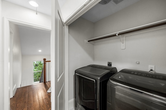 laundry area with dark wood-type flooring and washer and dryer