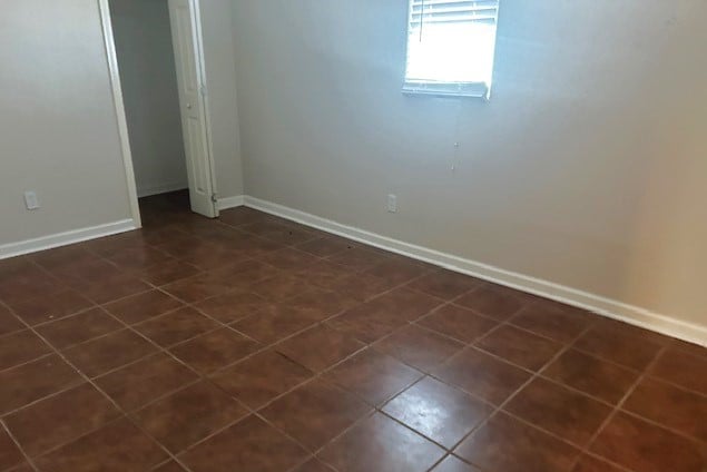 unfurnished bedroom featuring dark tile patterned floors and a closet