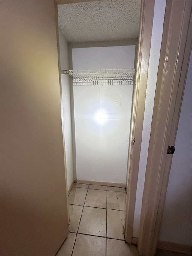 interior space featuring light tile patterned floors and a textured ceiling