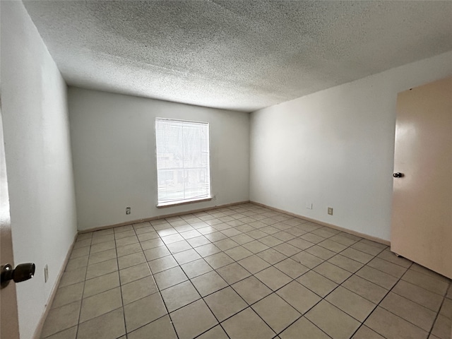 tiled spare room with a textured ceiling