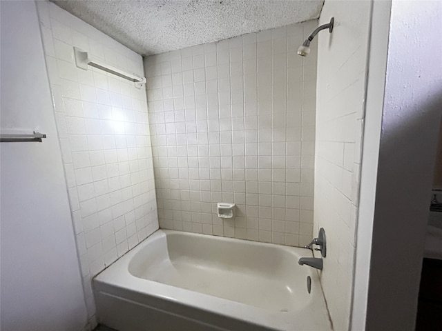 bathroom featuring tiled shower / bath and a textured ceiling