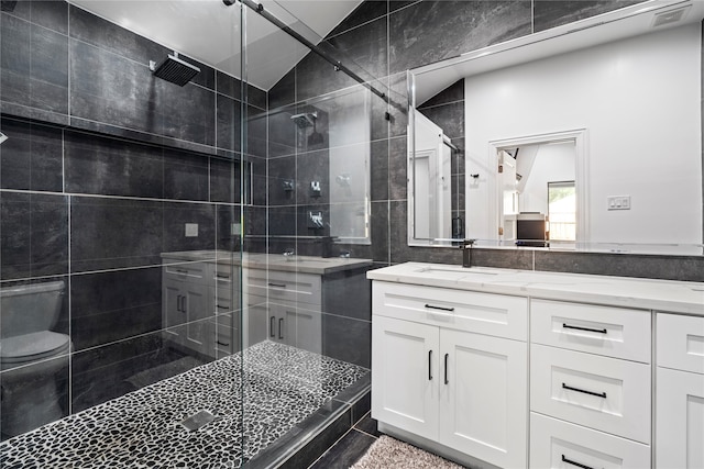 bathroom featuring a shower with door, vanity, toilet, and lofted ceiling